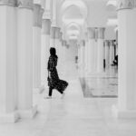 A woman in a long dress walking down a hallway